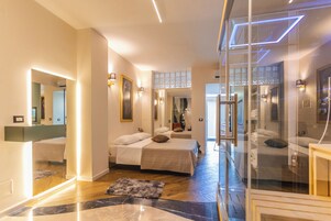 Una camera d'hotel moderna con due letti, una parete divisoria in vetro e un pavimento in marmo.