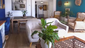 A living room with a sofa, armchairs, a dining table, and a potted plant. - Mikasi Hills by Hello Homes Sitges (Sitges)