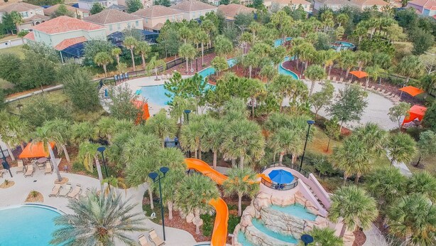 An aerial view of a resort with a swimming pool, water slides, and palm trees. - 5B/4.5B Pool and Resort (Davenport)