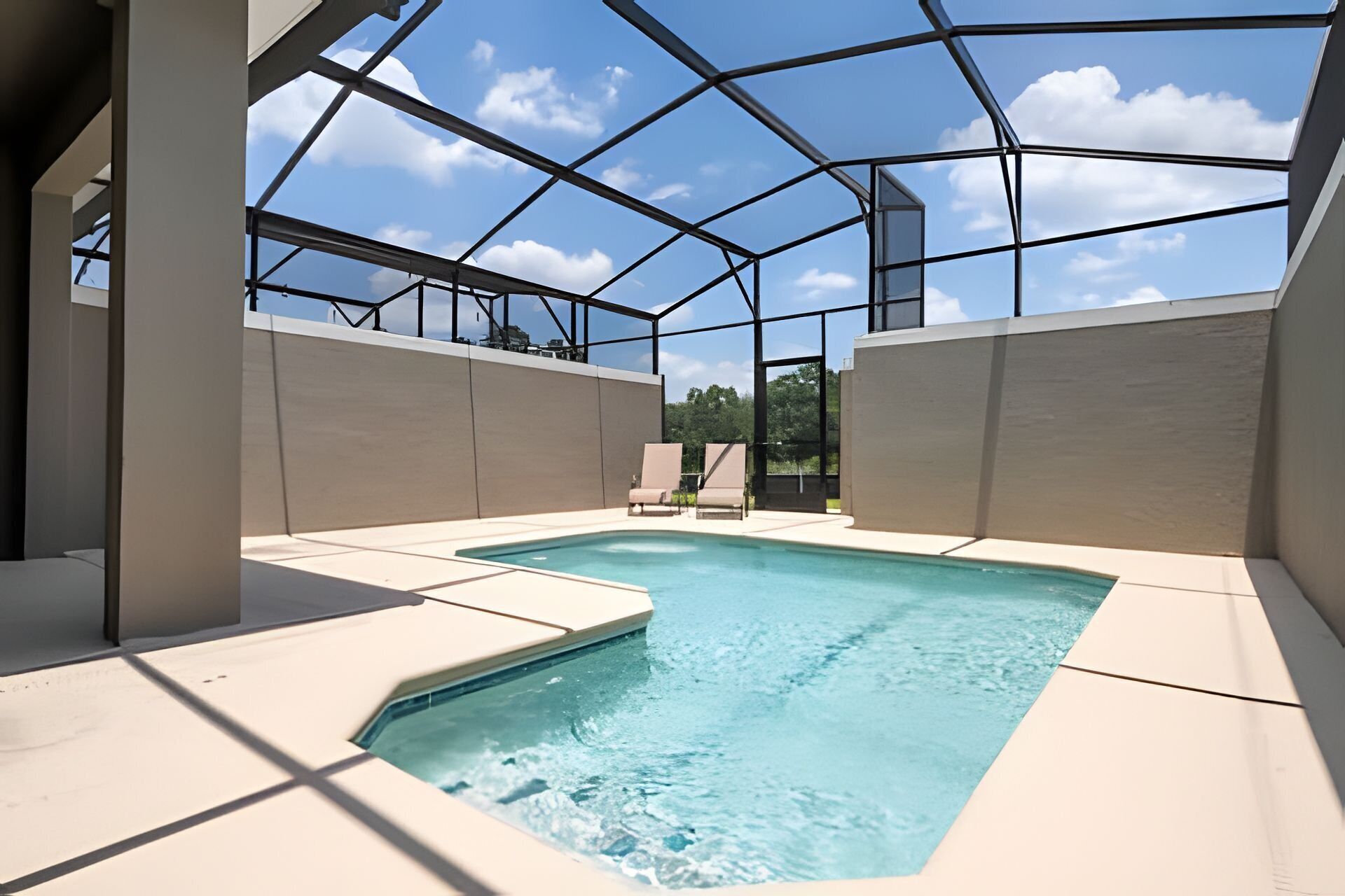 Una piscina interna moderna con tetto in vetro, circondata da pareti beige e vista aperta sul cielo.