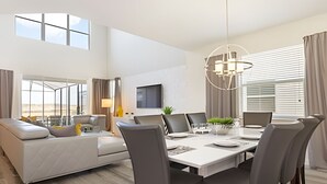 Een moderne hotelkamer met een zithoek, een sofa en een televisie.