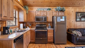 A kitchen with wooden cabinets, stainless steel appliances, a dishwasher, and a refrigerator.