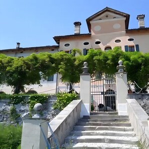 A building with a staircase leading to a gated entrance, surrounded by greenery. - Apartment 'Bivai - Merlot' with shared pool, private terrace and Wi-Fi (Bivai)
