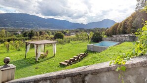 A grassy outdoor area with a pool, a pergola, and a row of chairs. - Apartment 'Bivai - Merlot' with Shared Pool, Private Terrace and Wi-Fi (Bivai)