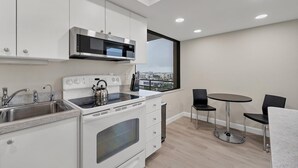 A modern kitchen with white cabinetry, a stainless steel range, and a window with a city view. - ANC903 Summary:<br>The A (Siesta Key)