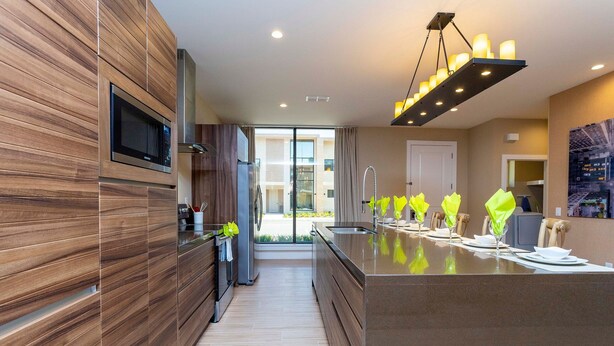 A modern kitchen with a built-in microwave, stainless steel appliances, and a large island with a sink.
