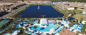 Un quartier résidentiel doté d’une grande piscine centrale, d’un court de tennis et d’une fontaine.