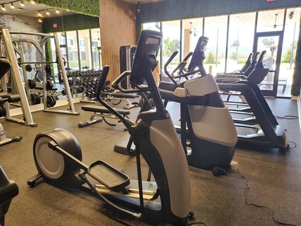 A gym with treadmills, elliptical machines, and weight machines.