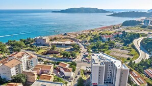An aerial view of a coastal town with buildings, roads, and a beach. - Princess Milena Apartments - Apartment Milena (Bečići)