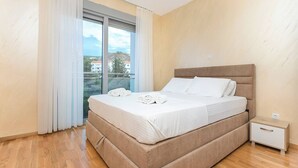 A hotel room with a bed, a nightstand, and a window with curtains. - Princess Milena Apartments - Apartment Milena (Bečići)