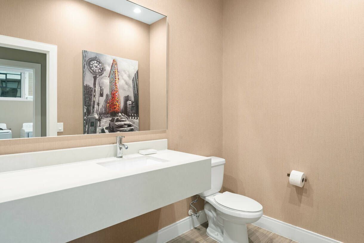 Ein Badezimmer mit Waschbecken, Toilette und Spiegel.