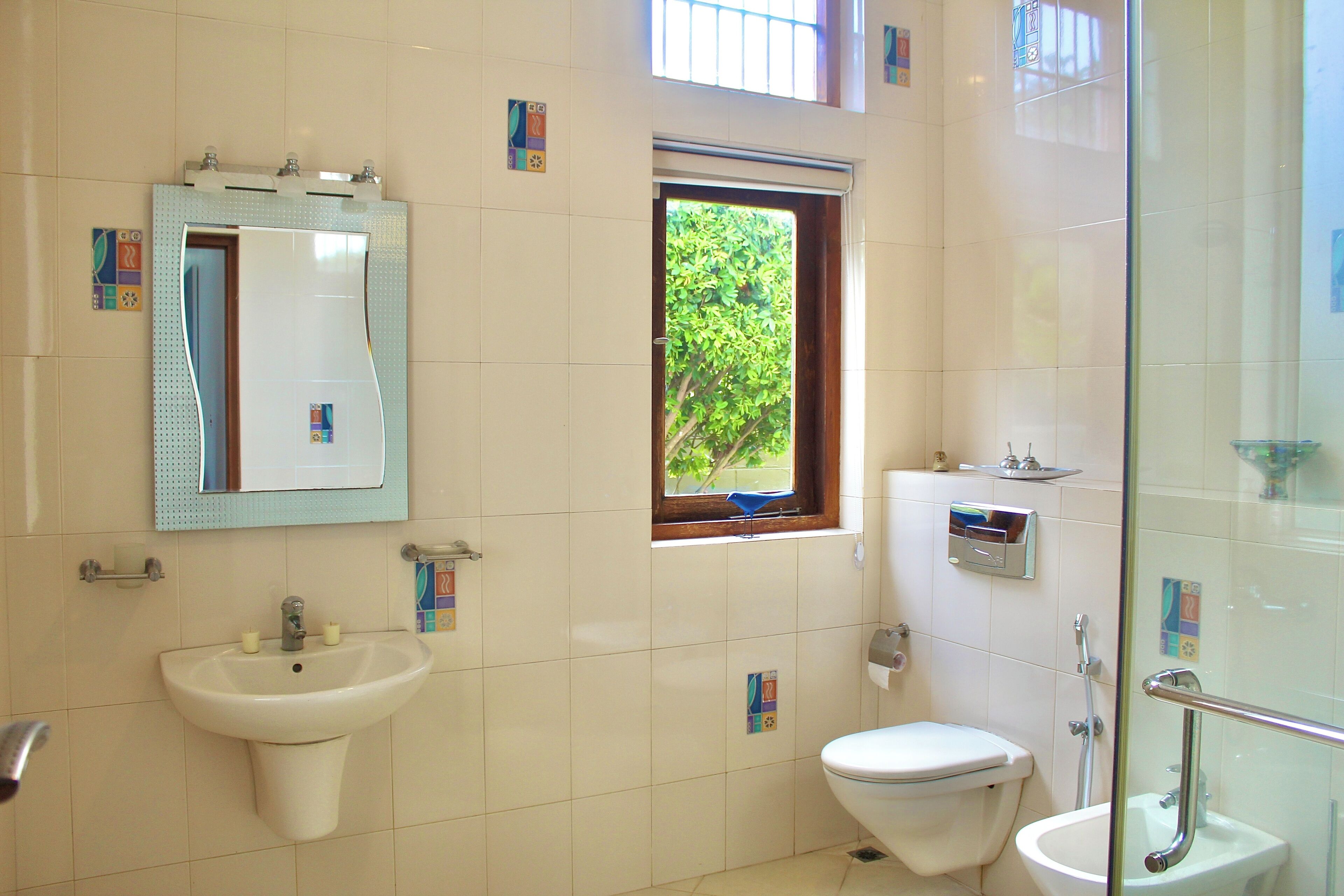 A modern bathroom with a sink, toilet, and shower.