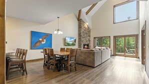 A spacious living area with a dining table, chairs, a sofa, and a fireplace.
