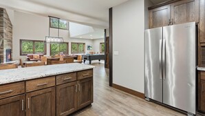 A spacious kitchen with a large island, wooden cabinets, and a stainless steel refrigerator. - Resort Amenities the Heart of Crosslake|Beach|Swim (Crosslake)