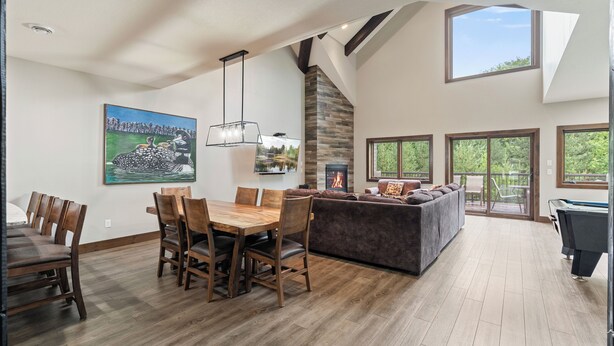 A spacious living area with a dining table, sofas, and a fireplace. - Resort Amenities the Heart of Crosslake|Beach|Swim (Crosslake)