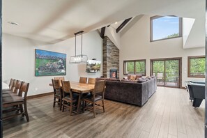 A spacious living area with a dining table, sofas, and a fireplace. - Resort Amenities the Heart of Crosslake|Beach|Swim (Crosslake)