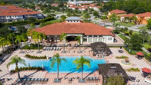 A resort with a swimming pool, lounge areas, and a covered pavilion. - Private Pool Home in Bella Vida Resort (Kissimmee)