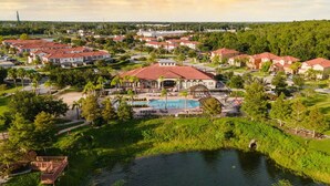 A residential area with houses, a swimming pool, and a small pond. - Themed House with Pool and Comfort (Kissimmee)
