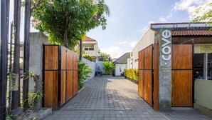 A gated entrance to a property named "Cove" with a paved pathway leading to the main building. - Cove Dahayu Sanctuary (Denpasar)