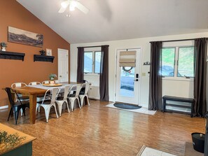A dining area with a wooden table and chairs, a ceiling fan, and a view through a door. - Spacious Mtn Chalet - Hot Tub & Minutes from Slopes, Trails, & Wineries (McGaheysville)