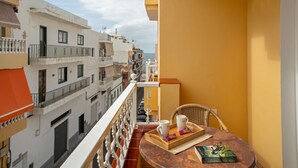 A balcony with a table, two cups, a tray, and a book.