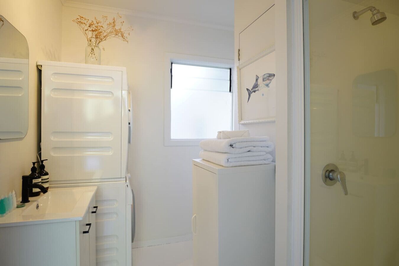 A compact bathroom with a sink, mirror, and a window.