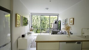 A modern kitchen with a large window, white cabinetry, and a central island.