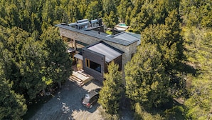 A modern two-story house with a sloped roof, surrounded by dense forest. - Apartments Bariloche - Lago Gutierrez (San Carlos de Bariloche)