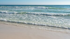 A beach with waves gently lapping onto the shore.