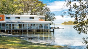 A waterfront building with a covered deck and outdoor seating area.