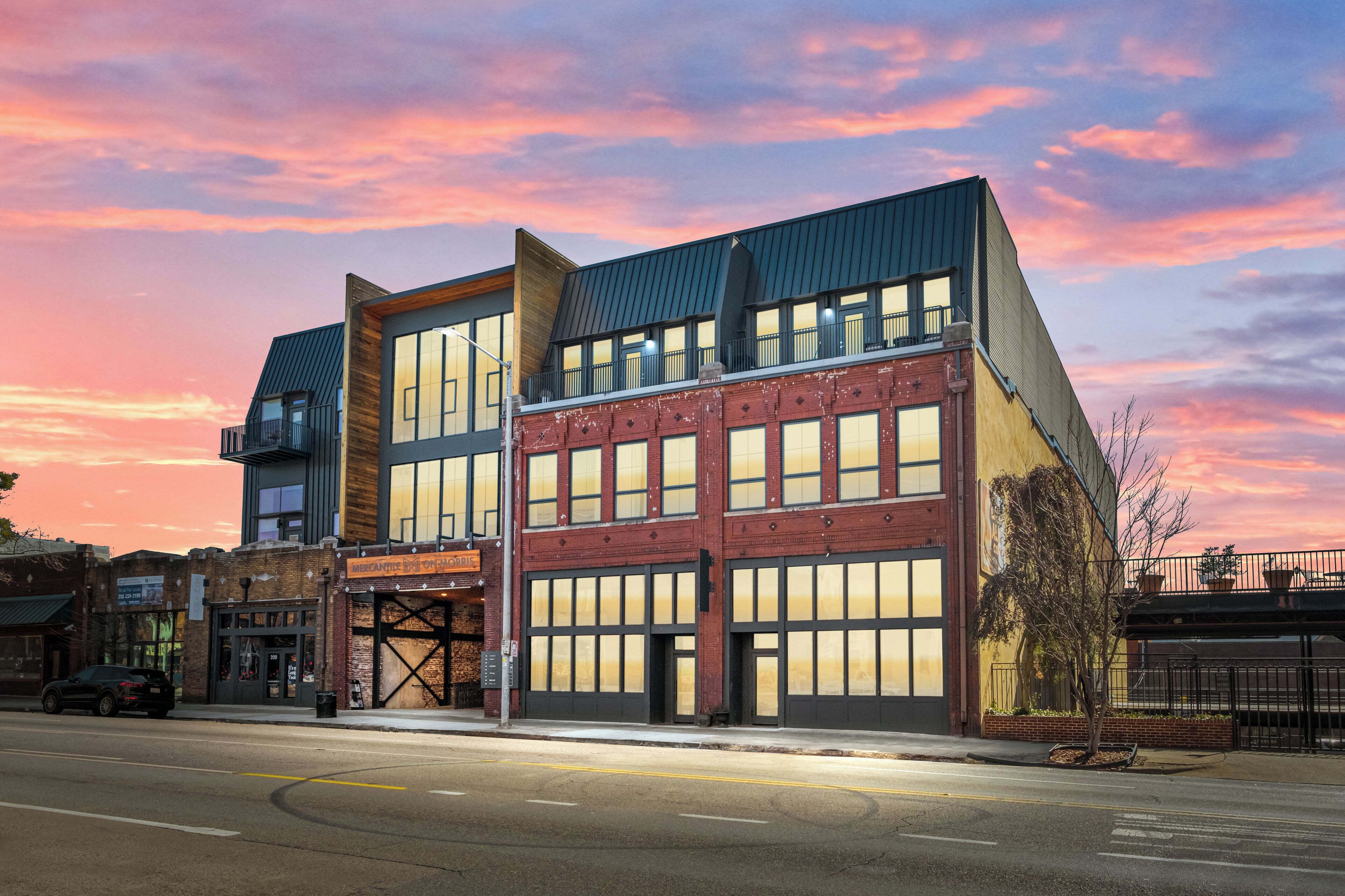 A modern building with large windows and a flat roof, located at a street corner.