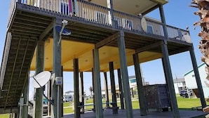 A two-story structure with a balcony and a covered patio area.