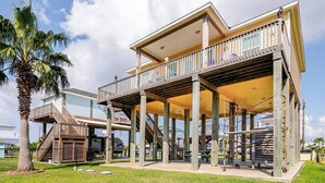 A multi-level house with a balcony, a staircase, and a pool area.