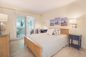 A bedroom with a bed, bedside table, lamp, and artwork on the wall. - Tranquil cottage overlooking the golf course (Edisto Island)