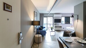 A modern hotel room with a sofa, dining table, and a TV. - Meu Anfitrião Nações Unidas (São Paulo)