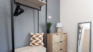 A room with a bed, a wooden dresser, a mirror, a lamp, and a plant. - 4 Bedroom Apartment Central Redcar (Redcar and Cleveland)