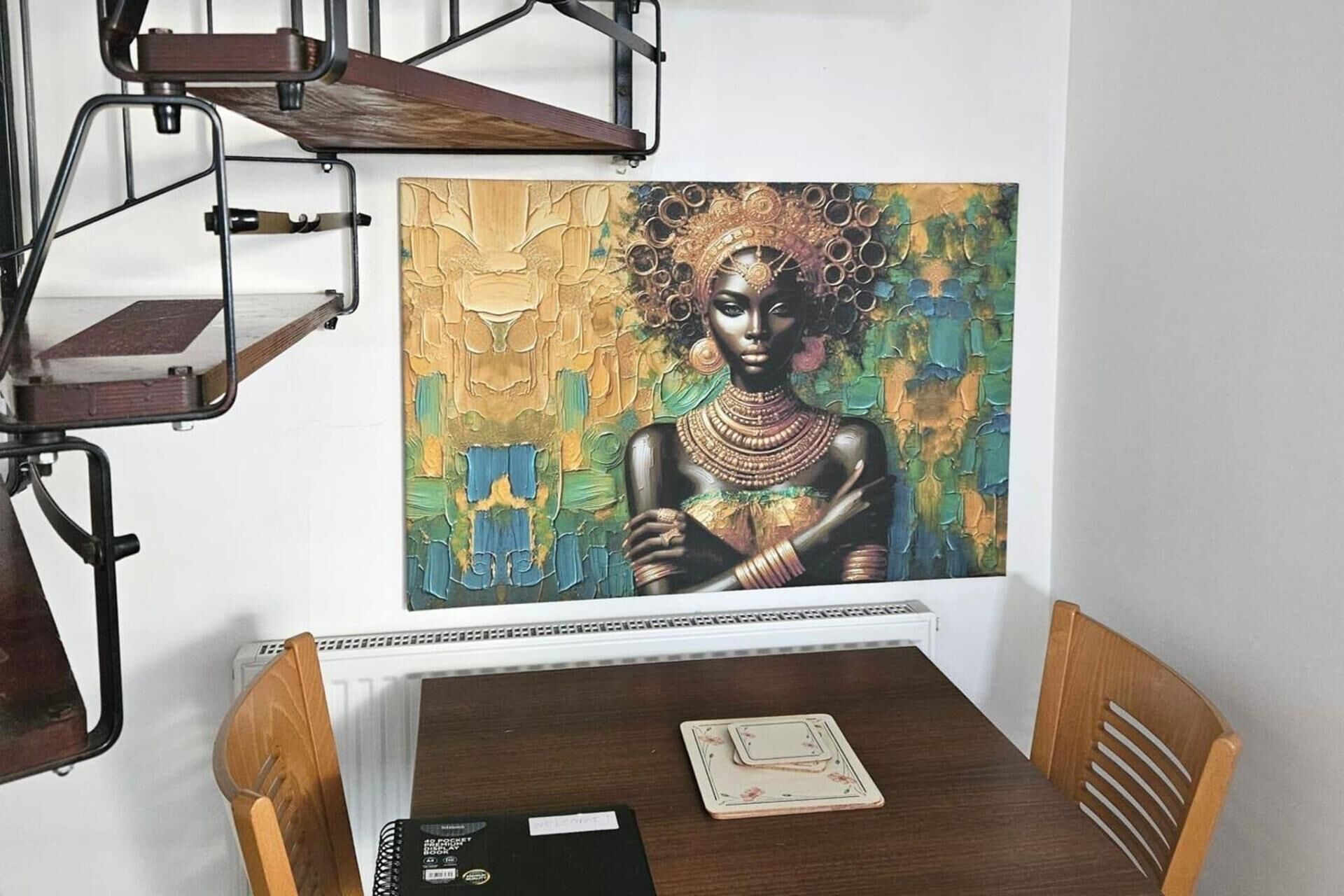 Ein Essbereich mit Tisch, Stühlen und einem Bild an der Wand.