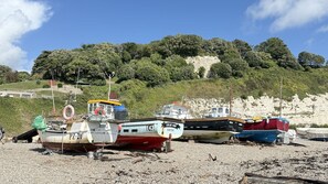 A beach with several boats moored on the shore.