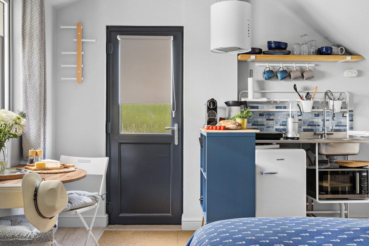Una kitchenette compacta con microondas, tostadora y cafetera.