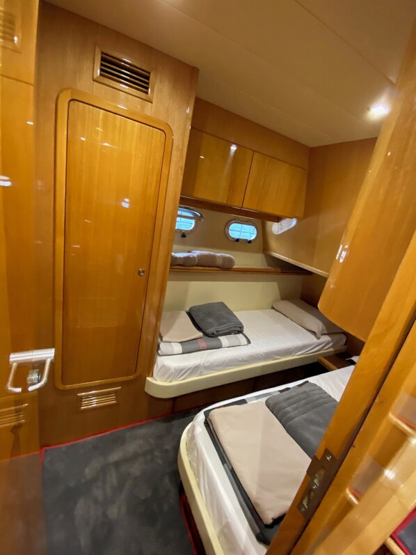 A compact RV interior with two bunk beds, a small kitchenette, and a wardrobe.