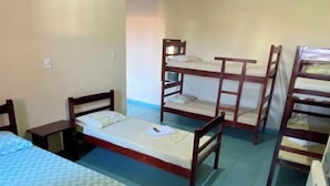 Une chambre de dortoir avec deux lits simples, un bureau et une chaise.