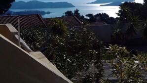 A coastal view with a clear sky, distant mountains, and a body of water.