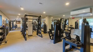 A gym with various exercise machines, mirrors, and a clear view of the outside. - Eco Resort Praia dos Carneiros Beachfront Apartment (Praia dos Carneiros)