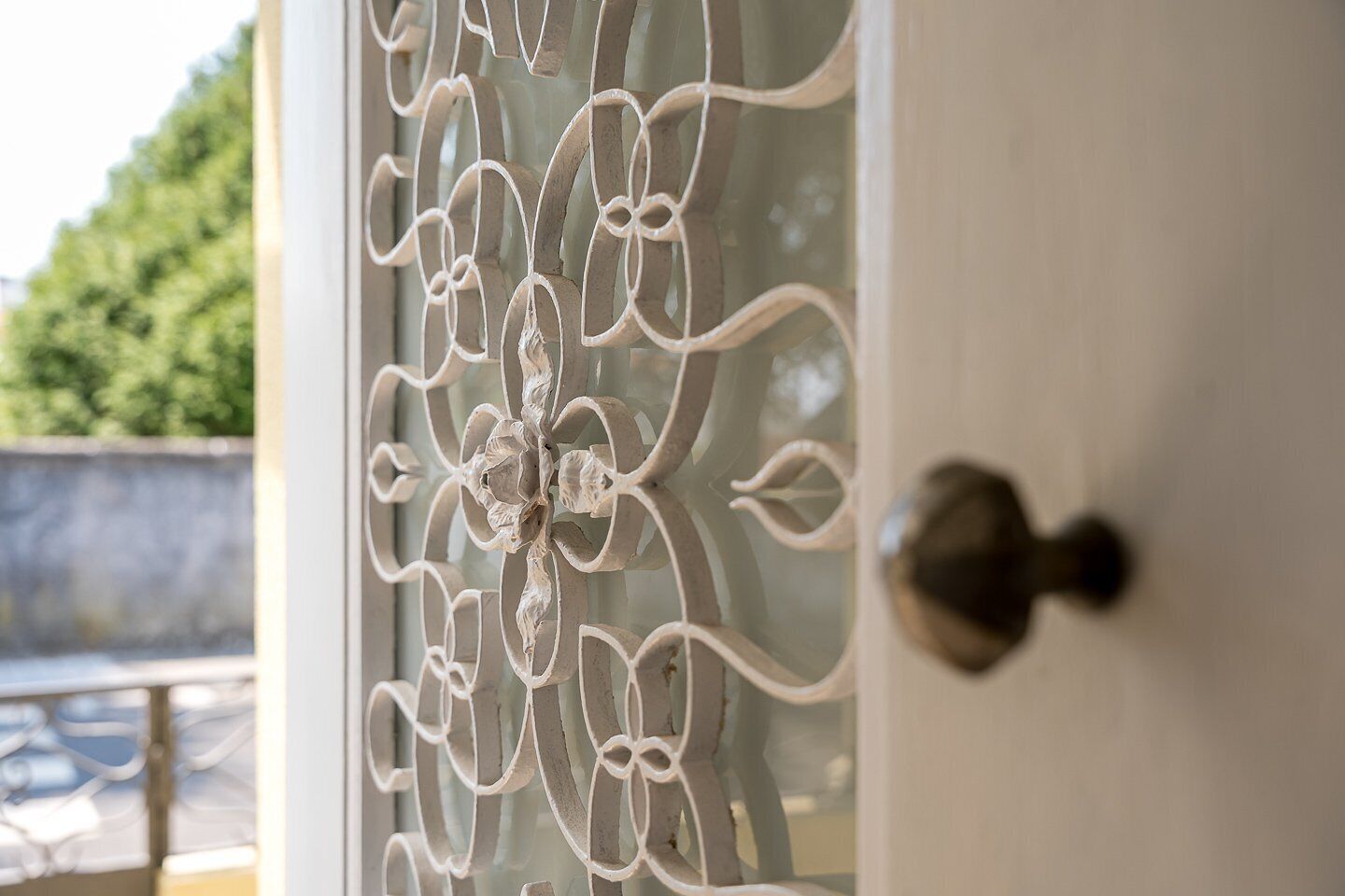 A door with a decorative metal design and a round, metallic handle.