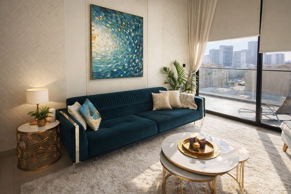 A modern living room with a teal sofa, a round coffee table, and a large painting.