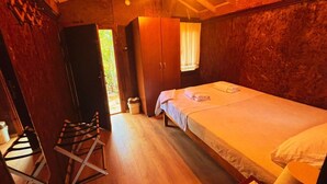 Quarto aconchegante com uma cama de madeira, uma mesa pequena com um menu e uma janela com cortinas.