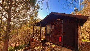 Uma cabana rústica com fachada de madeira, varanda e extintor de incêndio.