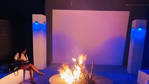 A circular outdoor seating area with a fire feature in the center, surrounded by hexagonal tiles. - Luxurious Motherland Apartments (Lusaka)
