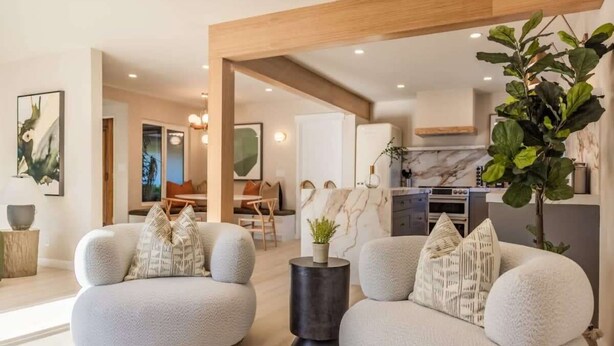 A modern living room with two round sofas, a small side table, and a large potted plant. - @ Marbella Lane - Vibrant & Chic Designer Home (Fullerton)