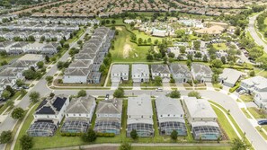 A residential area with houses, roads, and a swimming pool.